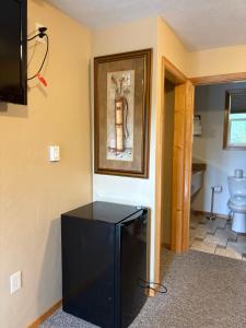 a black refrigerator in a room with a picture on the wall at Glacier Highland Motel in West Glacier