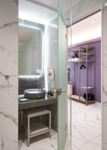 a bathroom with a sink and a glass door at 24K Athena Suites in Athens +94 photos