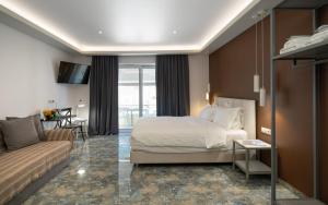 a hotel room with a bed and a couch at 24K Athena Suites in Athens