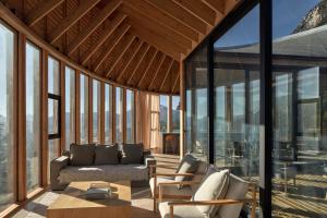 a living room with a couch and chairs and windows at Punto Cero Patagonia in Bahía Murta