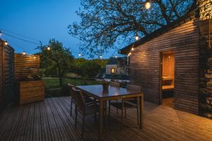 a patio with a table and chairs on a wooden deck at Private spa - La Sparenthèse in Ciney