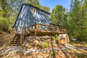 a house on top of a hill with a deck at Riverfront retreat with panoramic river and forest views in Rhododendron
