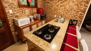 a kitchen with a stove and a counter top at Refúgio Casinha Branca in Duque de Caxias