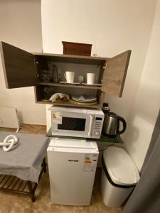 a kitchen with a microwave and a trash can at Casita de Norma, Mercedes Corrientes!!! in Mercedes +3 photos