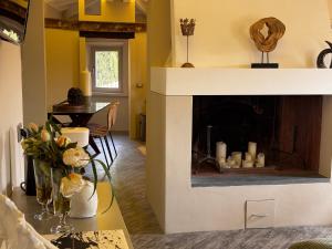 a living room with a fireplace and a table with flowers at La Casetta di Borgo Appartamento Albero in Lajatico
