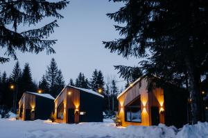 two houses in the snow with lights on them at Monside Resort - FIRE CABIN in Borzont +6 photos