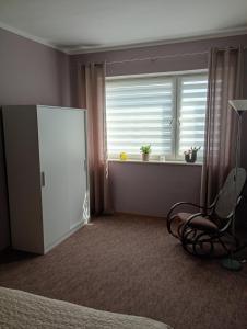 a bedroom with a window and a chair and a windowpectpect at Pokoje w Pucku u Ewy in Puck