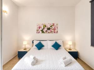 a bedroom with a white bed with towels on it at Corte Dei Fiori Acquaviva Apartments in Marittima