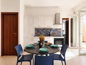 a dining room with a table and chairs in a kitchen at Corte Dei Fiori Acquaviva Apartments in Marittima