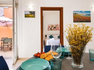 a table with a bowl of fruit and a vase at Corte Dei Fiori Acquaviva Apartments in Marittima