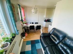 a living room with a table and a leather couch at Adam1 in Uppsala +17 photos