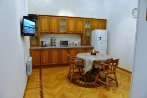 a kitchen with a table and chairs and a television at Baku Home Hostel in Baku