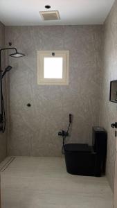 a bathroom with a toilet and a window on the wall at شقة مفروشة أنيقة وهادئه in Al Ahsa