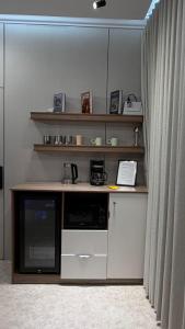 a kitchen with a desk with a microwave and a curtain at شقة مفروشة أنيقة وهادئه in Al Ahsa +2 photos