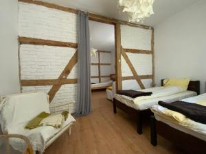 a room with two beds and a white brick wall at Stary młyn nad Tywą in Gryfino
