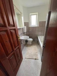 a bathroom with a toilet and a sink and a door at Canovic vacation in Plav