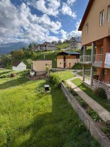 a house with a green yard next to a building at Canovic vacation in Plav