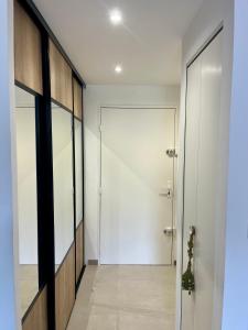 a hallway with a white door and a glass wall at Cosy Sunnyland, accès direct plage et parking privatif in La Grande Motte