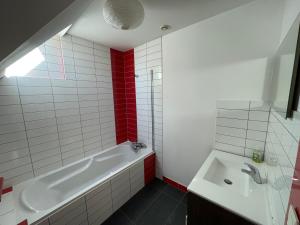 a white bathroom with a tub and a sink at Maisons avec terrasse et parking in Colmar +20 photos