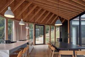 a kitchen with a table and chairs and windows at Punto Cero Patagonia in Bahía Murta
