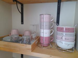 a shelf with pink and white vases on it at Chambre calme Aux Iris in Grandvelle-et-Perrenot