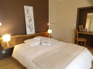 a bedroom with a large white bed with two lamps at Chambre calme Aux Iris in Grandvelle-et-Perrenot