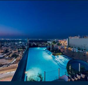 a large swimming pool on top of a building at Golden Studio With Swimming pool in Jaipur