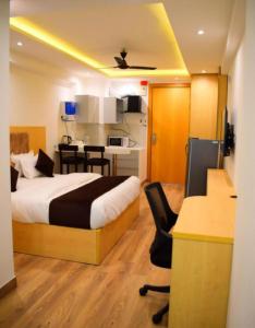 a bedroom with a bed and a desk and a kitchen at Golden Studio With Swimming pool in Jaipur +26 photos