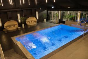 a large blue swimming pool with two chairs in a room at Park Hall Cottages ,Chorley, Preston,Lancashire in Chorley