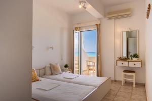 a bedroom with two beds and a view of the ocean at Nefeli Rooms with Sea View in Kalamaki in Kalamaki +15 photos