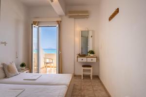 a bedroom with a bed and a view of the ocean at Nefeli Rooms with Sea View in Kalamaki in Kalamaki
