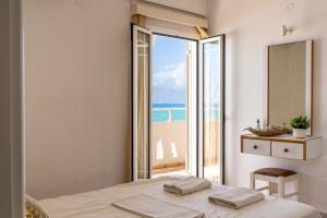 a bedroom with a bed and a view of the ocean at Nefeli Rooms with Sea View in Kalamaki in Kalamaki