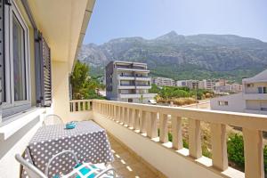 a balcony with a table and a view of mountains at Apartmani Villa Antonio in Makarska