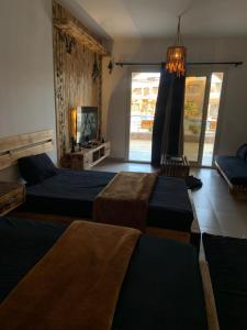 a bedroom with three beds and a large window at Arwaa Boutique in Dahab