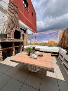 a patio with a table and a brick fireplace at Appart 10 pers - Lille Lambersart - Parking & Terrasses in Lambersart
