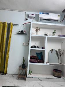 a room with a white shelf with a mirror at Shiva in Hāpur +3 photos
