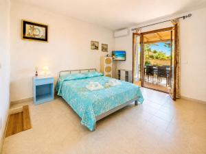 a bedroom with a bed and a television and a balcony at Baja Sardinia Casetta Belvedere 2 with Pool 100m from the Beach in Baja Sardinia