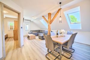 a dining room and living room with a table and chairs at Apartmaji na Pošti in Podsreda
