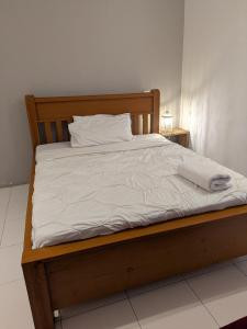 a bed with white sheets and pillows on it at Almasi lounge in Arusha