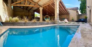 a swimming pool in a backyard with a wooden pergola at Agréable bastide provençale avec piscine in Barcelonne