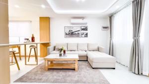 a living room with a white couch and a table at Pattaya Tropical Pool Villa in Pattaya