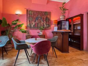 a pink room with a table and some chairs at Hotel Botaniek in Bruges