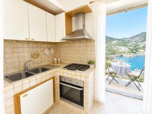 a kitchen with a stove top oven next to a balcony at Maridea - Appartamento al Tramonto in Ponza