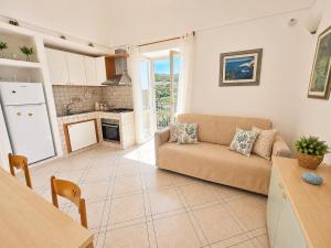 a living room with a couch and a kitchen at Maridea - Appartamento al Tramonto in Ponza