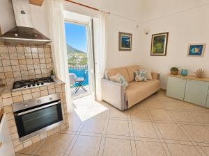 a living room with a couch and a stove at Maridea - Appartamento al Tramonto in Ponza