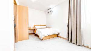 a small bedroom with a bed and a window at Pattaya Tropical Pool Villa in Pattaya