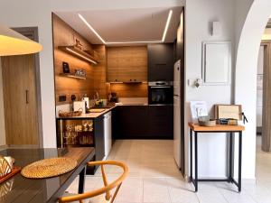 a kitchen with black cabinets and a table and chairs at Olive Apartment in Tala