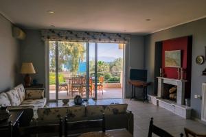 a living room with a couch and a large window at Aphrodite Residence - Seafront apartment, Melissi in Melíssion