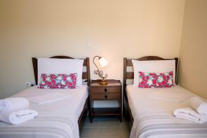 two beds sitting next to each other in a room at Aphrodite Residence - Seafront apartment, Melissi in Melíssion