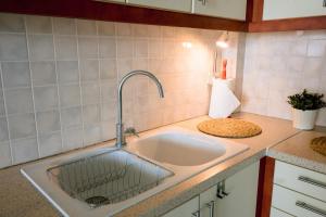 a kitchen sink with a faucet on a counter at Aphrodite Residence - Seafront apartment, Melissi in Melíssion +52 photos